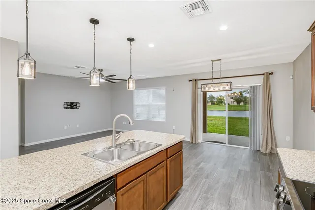 a kitchen with a sink a stove and a wooden floor