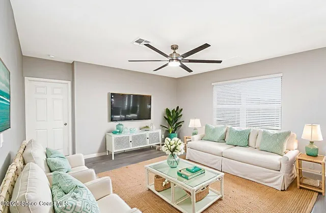 a living room with furniture a window and a flat screen tv