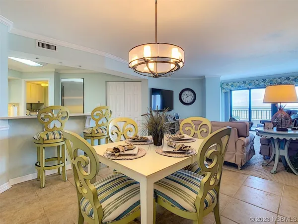 a view of a dining room with furniture and chandelier