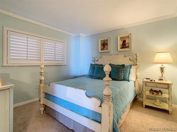 a bedroom with a bed and a lamp on the dresser