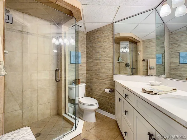 a bathroom with a granite countertop sink a toilet and shower