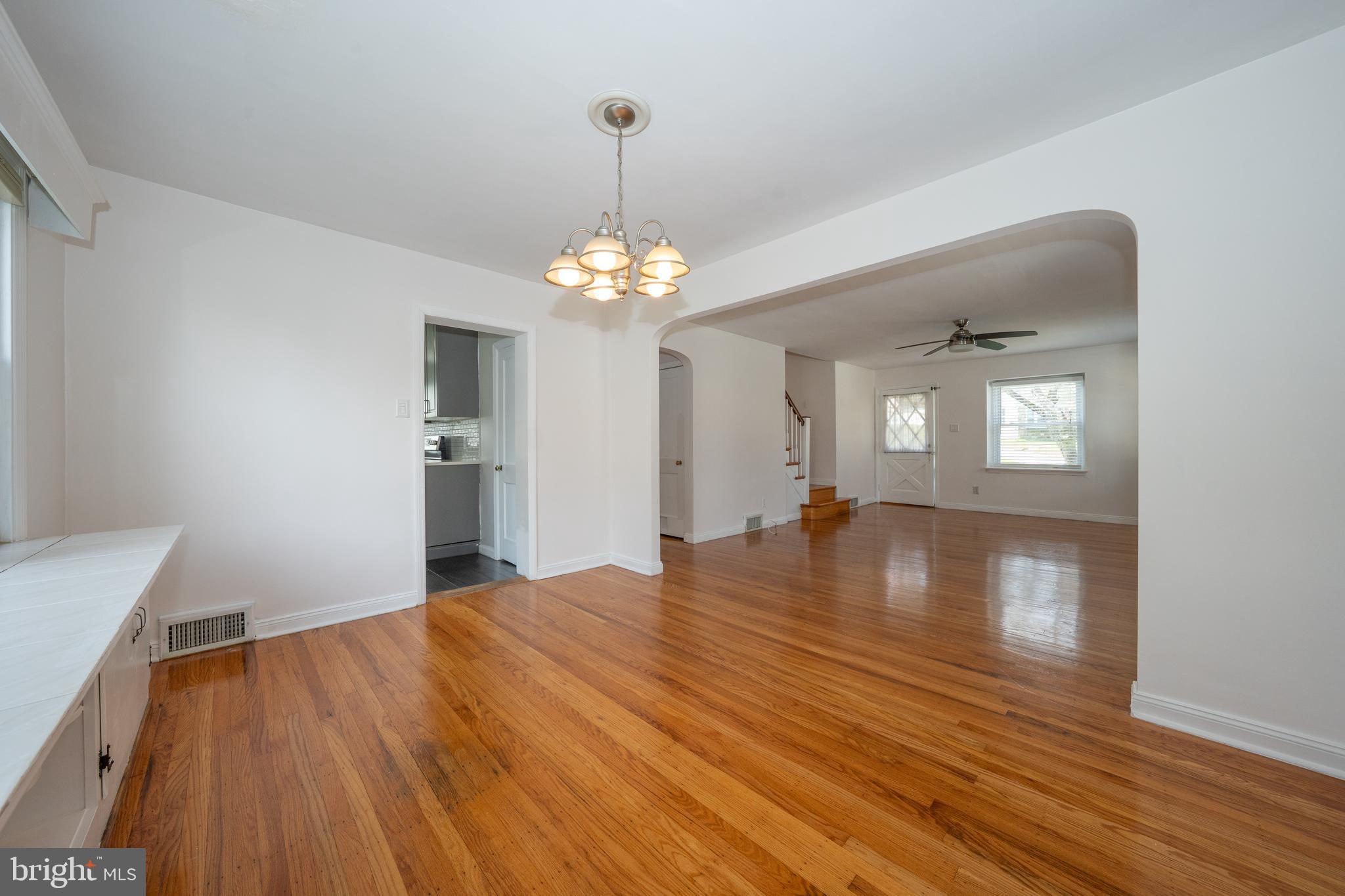 1305 Center Road Drexel Hill, PA 19026 - Photo 10 of 37 a view of empty room with wooden floor and kitchen view