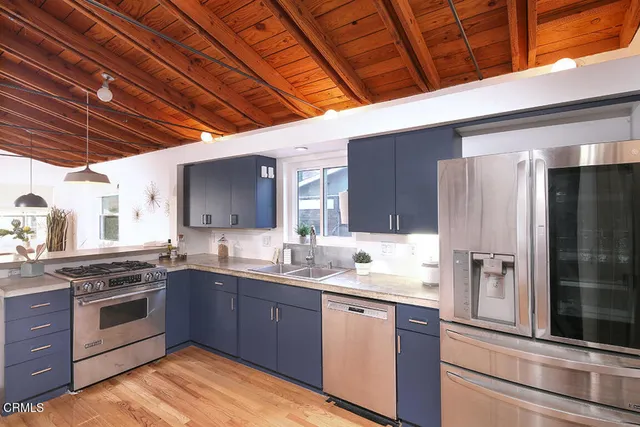 a kitchen with stainless steel appliances granite countertop a stove sink and refrigerator