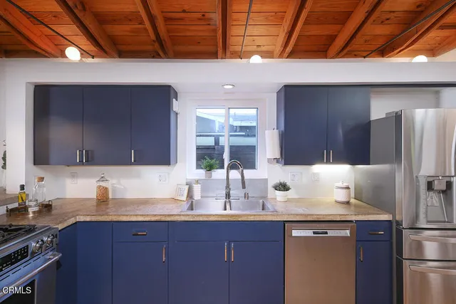 a kitchen with granite countertop a sink stove and refrigerator