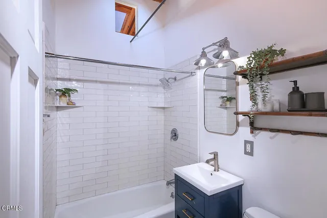 a bathroom with a sink mirror and a bathtub