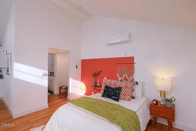 a bedroom with a bed and wooden floor