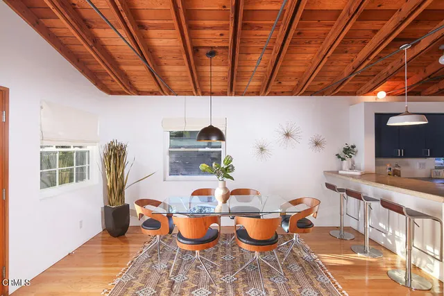 a dining room with furniture and a potted plant