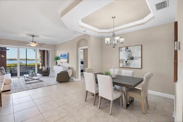 a living room with furniture a chandelier and a large window