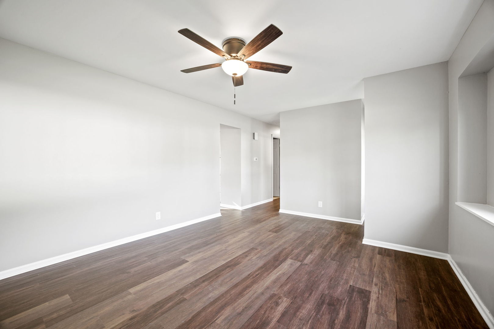 130 Saugatuck Road Montgomery, IL 60538 - Photo 4 of 31 an empty room with wooden floor and ceiling fan