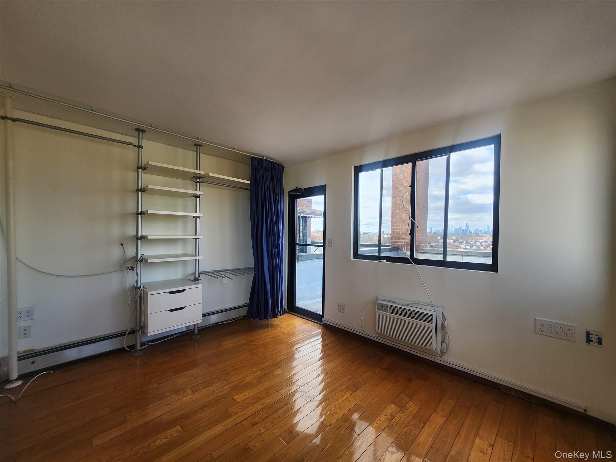 87-14 57th Road, Unit PHA Queens, NY 11373 - Photo 12 of 15 an empty room with wooden floor closet and windows