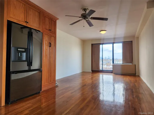 a view of empty room with wooden floor and window