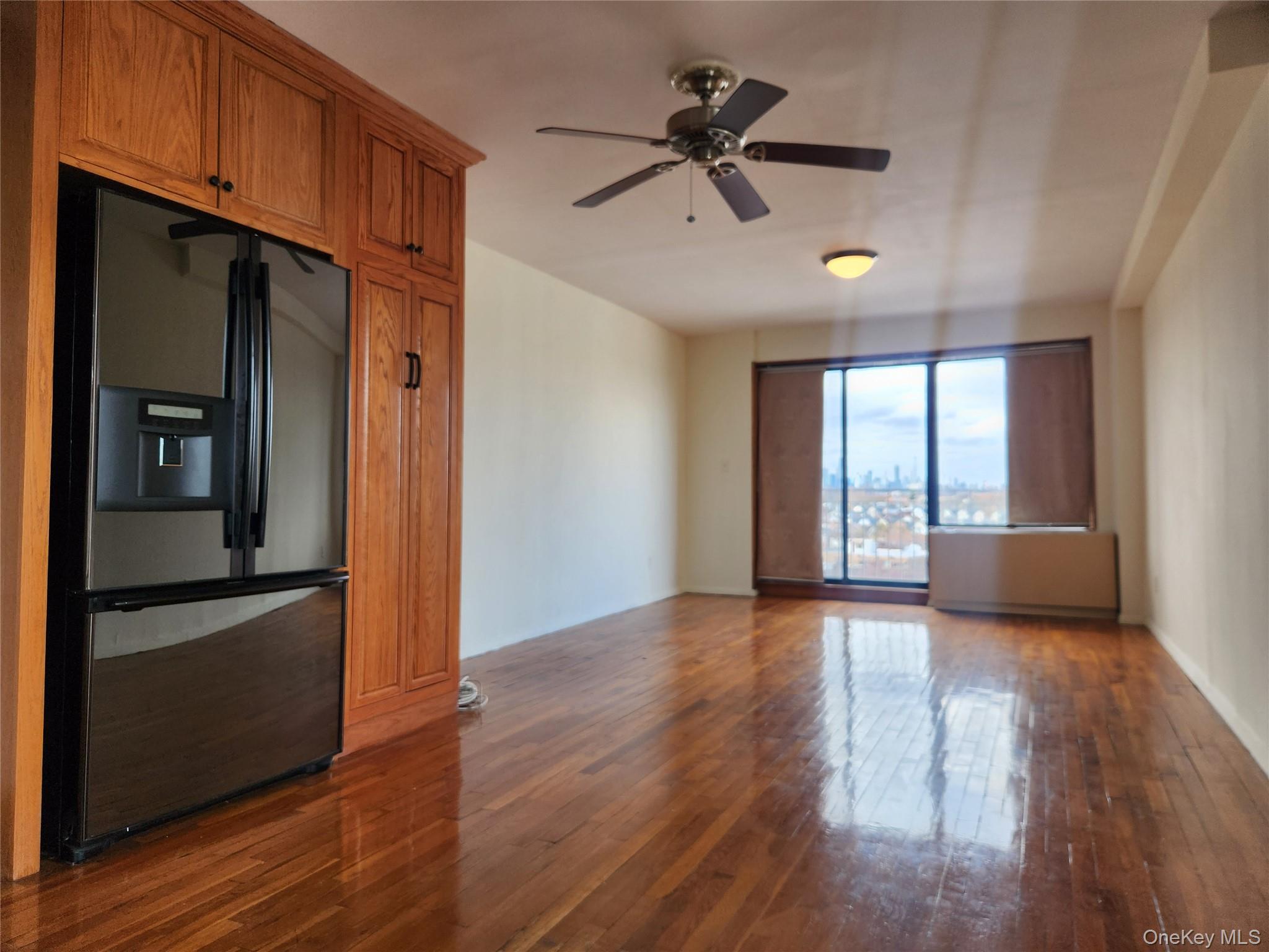 87-14 57th Road, Unit PHA Queens, NY 11373 - Photo 2 of 15 a view of empty room with wooden floor and window