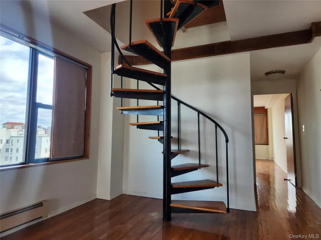 a view of an entryway with wooden floor and door