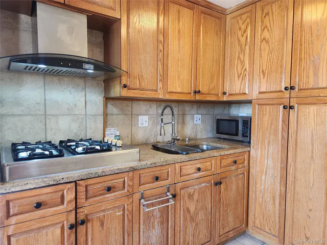a kitchen with granite countertop a sink a stove and cabinets