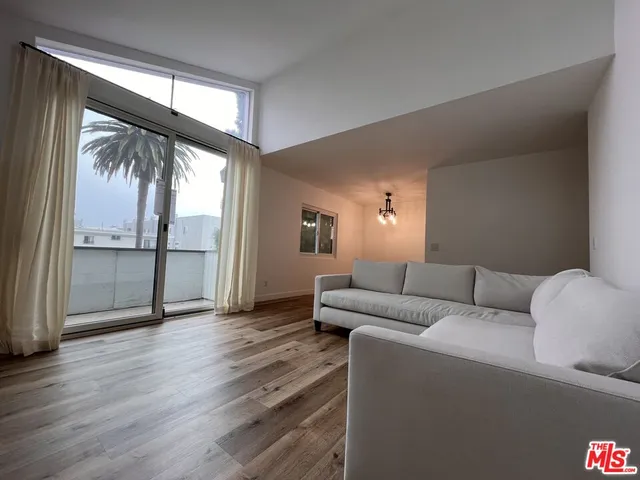 a living room with furniture and a floor to ceiling window