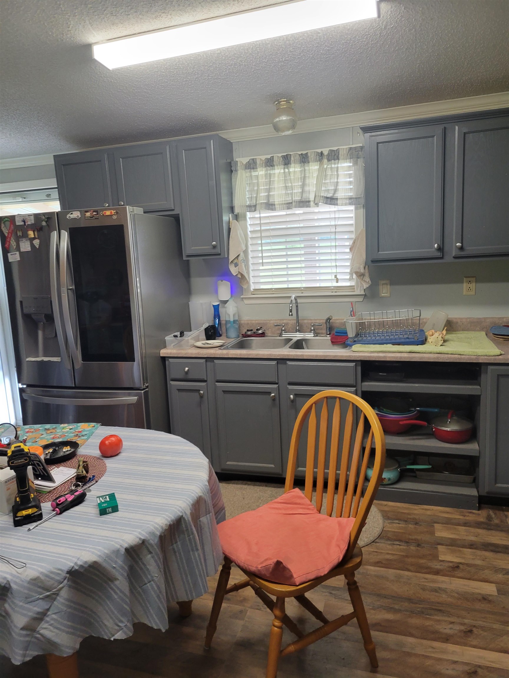 2496 Detroit Road Burlison, TN 38015 - Photo 8 of 25 Kitchen with stainless steel refrigerator with ice dispenser, gray cabinets, wood finished floors, a textured ceiling, and light countertops