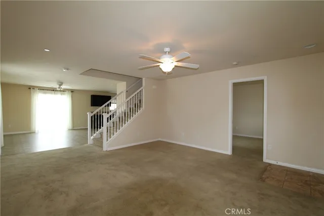 an empty room with ceiling fan and window