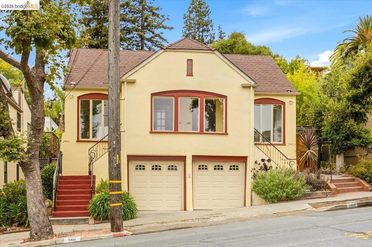 2403 Cedar Street Berkeley, CA 94708 - Photo 2 of 33 Stucco exterior with a peaked roofline, two single-car garages, and two distinct entry staircases with wrought iron railings