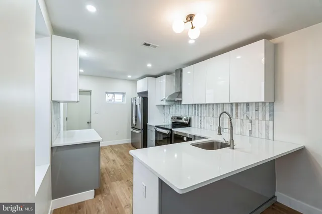 a kitchen with a sink a stove a refrigerator and cabinets