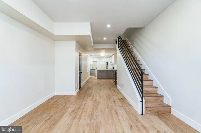 a view of a hallway with wooden floor and staircase