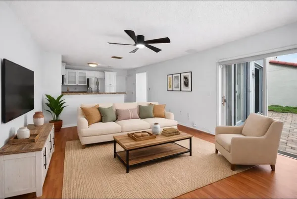 a view of a kitchen with wooden floor and a ceiling fan