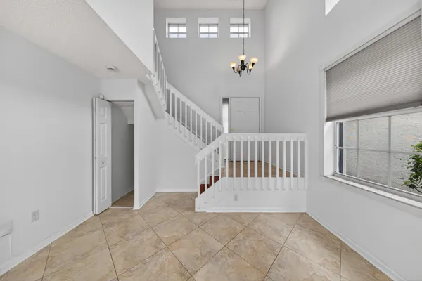 a view of staircase with railing and a chandelier