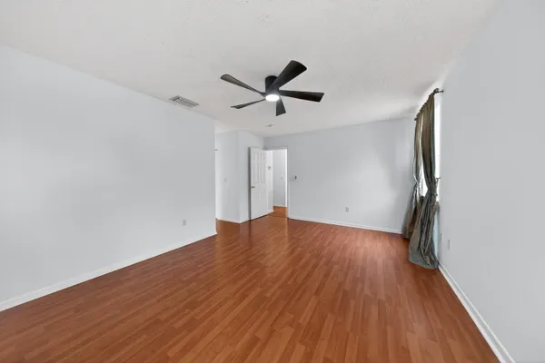 an empty room with a window and a ceiling fan
