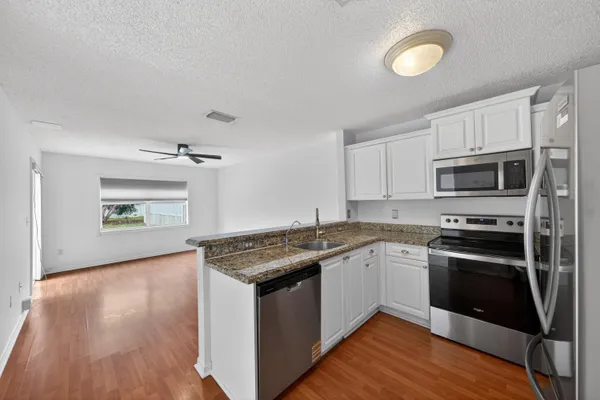 a view of kitchen with stainless steel appliances granite countertop refrigerator sink and stove