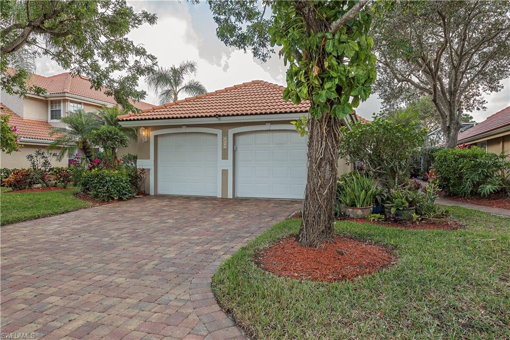 144 Napa Ridge Way Naples, FL 34119 - Photo 2 of 12 a front view of a house with garden