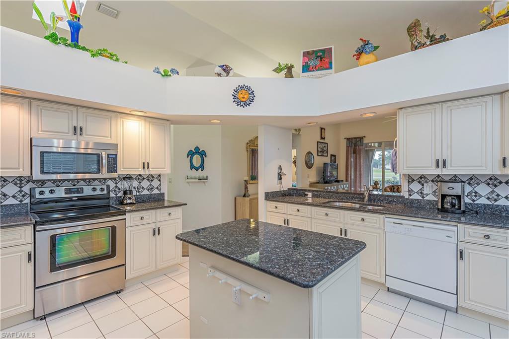 144 Napa Ridge Way Naples, FL 34119 - Photo 3 of 12 a kitchen with a stove top oven sink and cabinets