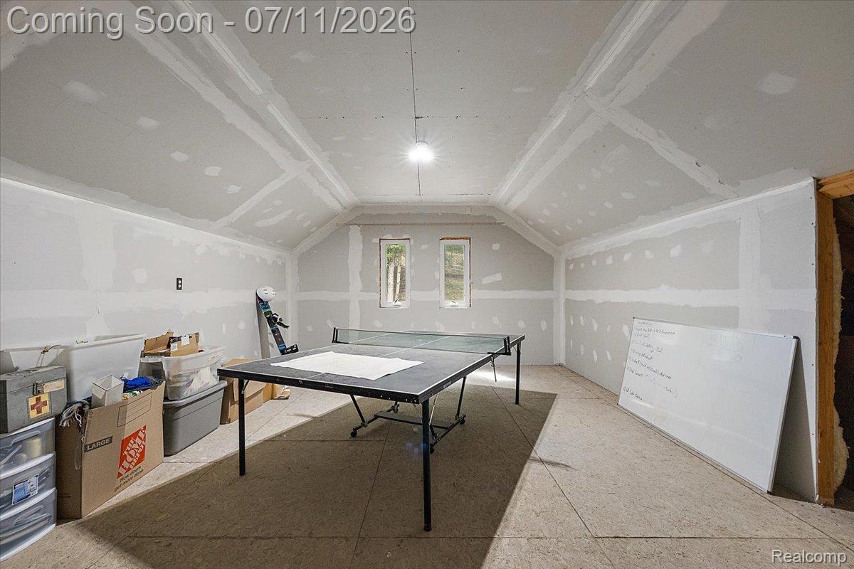 4219 Gardner Road Metamora, MI 48455 - Photo 61 of 87 Room featuring vaulted ceilings with exposed beams, drywall-finished walls, and two small windows providing natural light