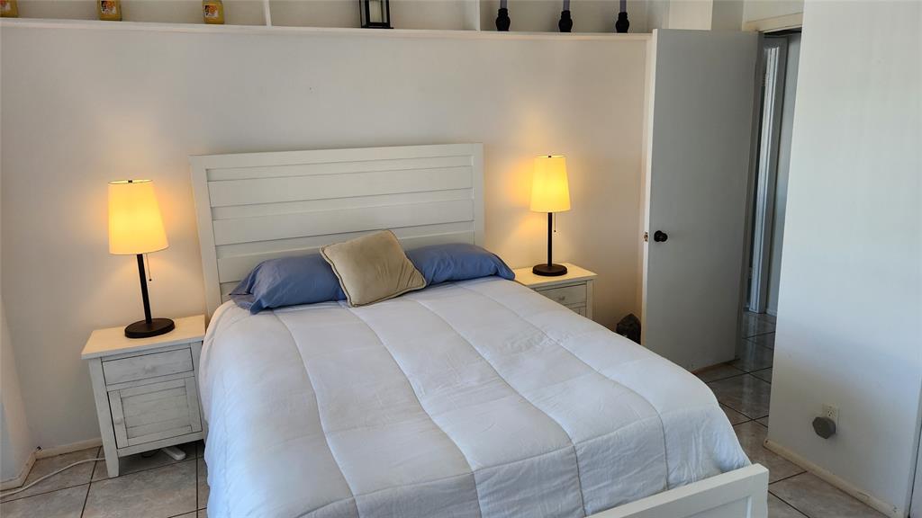 405 North Ocean Boulevard, Unit 1507 Pompano Beach, FL 33062 - Photo 12 of 19 a bedroom with a bed and a lamp