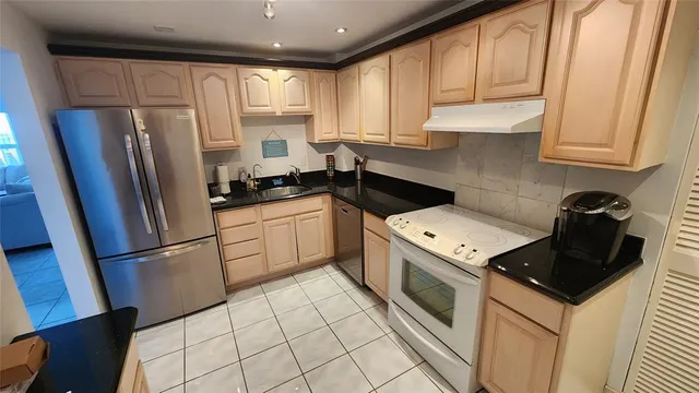 a kitchen with a refrigerator sink and cabinets