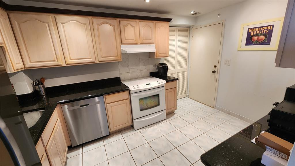 405 North Ocean Boulevard, Unit 1507 Pompano Beach, FL 33062 - Photo 3 of 19 a kitchen with granite countertop a stove a sink and a microwave