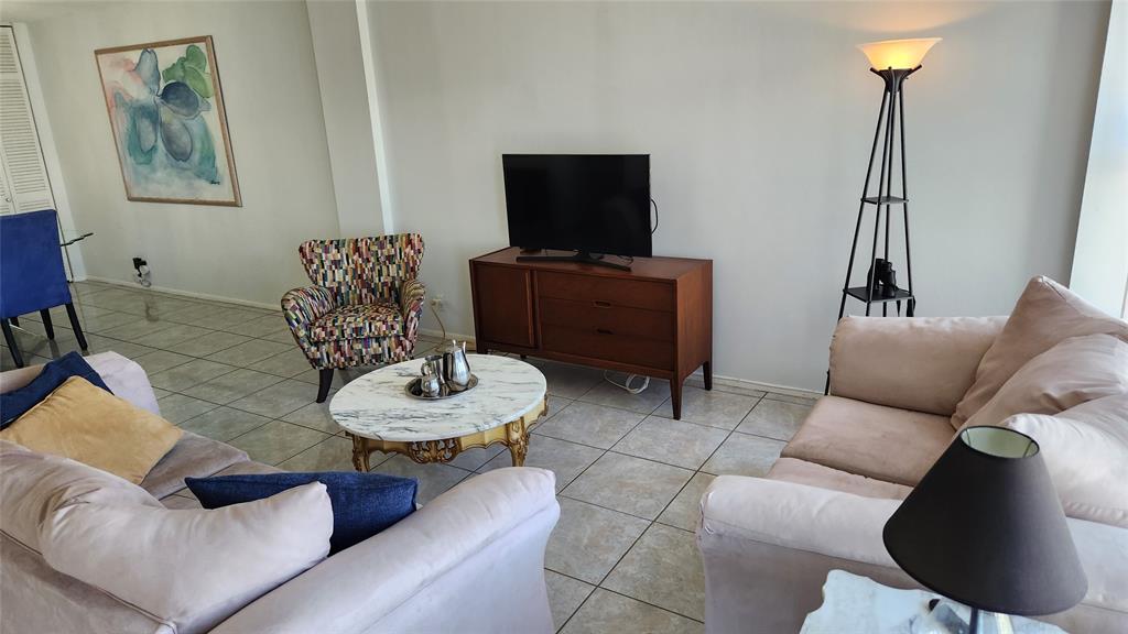 405 North Ocean Boulevard, Unit 1507 Pompano Beach, FL 33062 - Photo 4 of 19 a living room with furniture and a flat screen tv