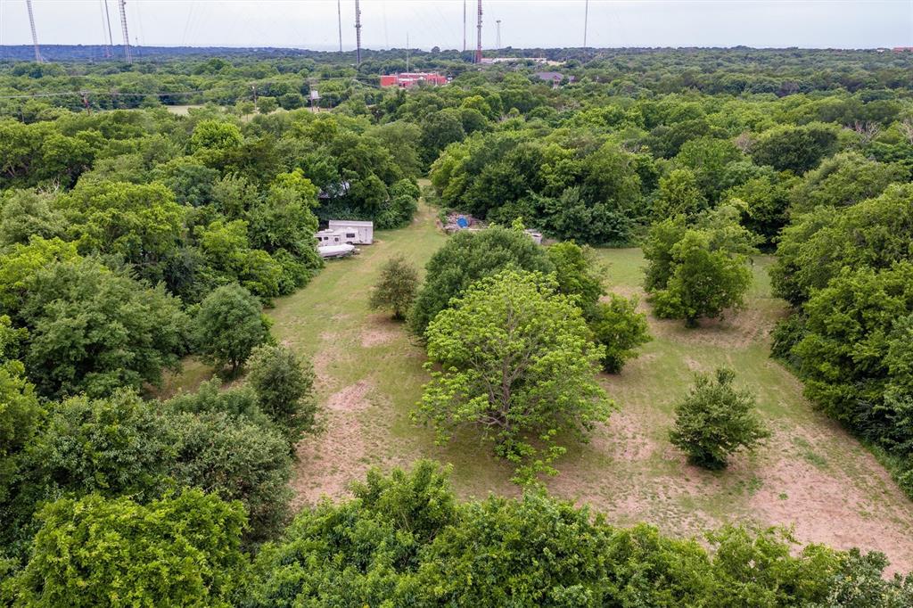 1007 West Belt Line Road Cedar Hill, TX 75104 - Photo 11 of 30 Expansive treed lot featuring a clearing with a white structure and a recreational vehicle