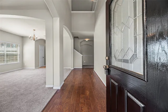 a view of a hallway with wooden floor and staircase