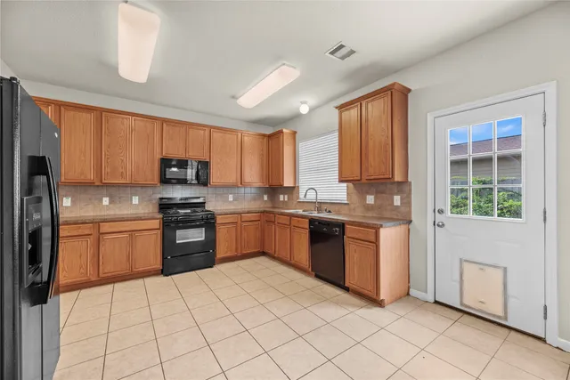 a kitchen with stainless steel appliances granite countertop a refrigerator sink and stove