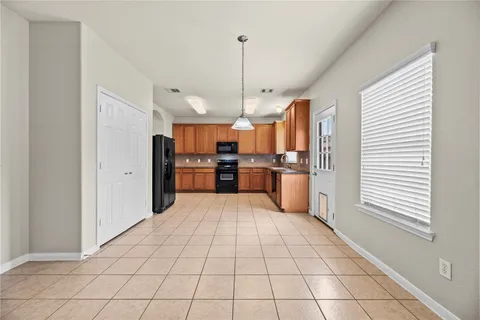 a large kitchen with kitchen island granite countertop a refrigerator and a stove top oven
