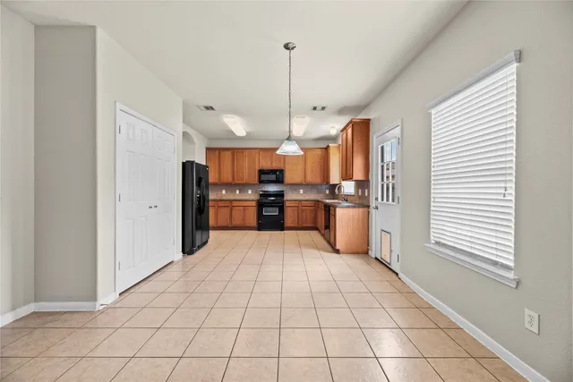 a large kitchen with kitchen island granite countertop a refrigerator and a stove top oven