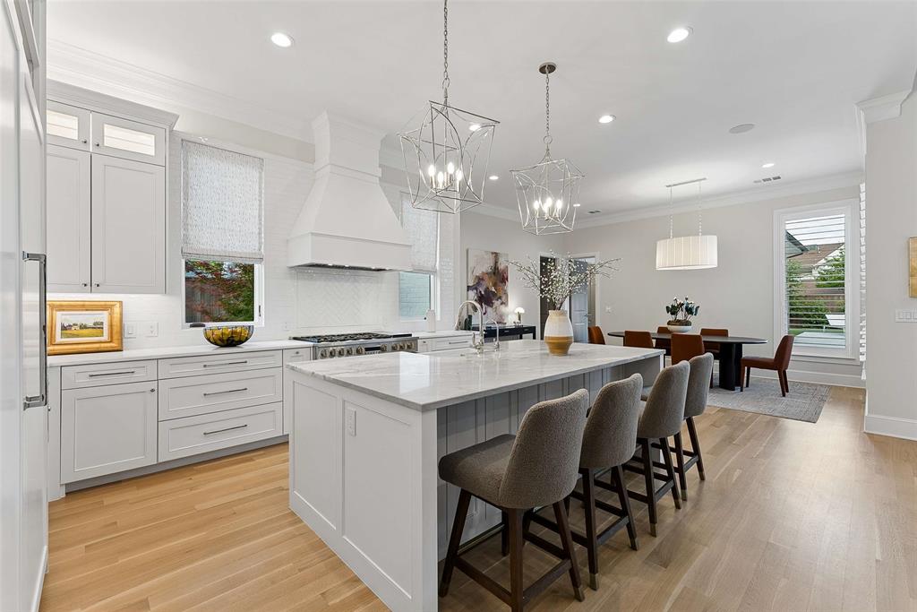 7110 Robin Road Dallas, TX 75209 - Photo 11 of 36 a kitchen with stainless steel appliances a table chairs sink and cabinets