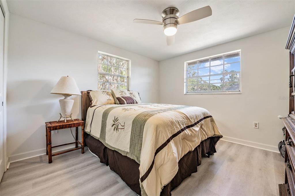 4450 Sunstate Drive New Port Richey, FL 34652 - Photo 16 of 29 a spacious bedroom with a bed and a chandelier