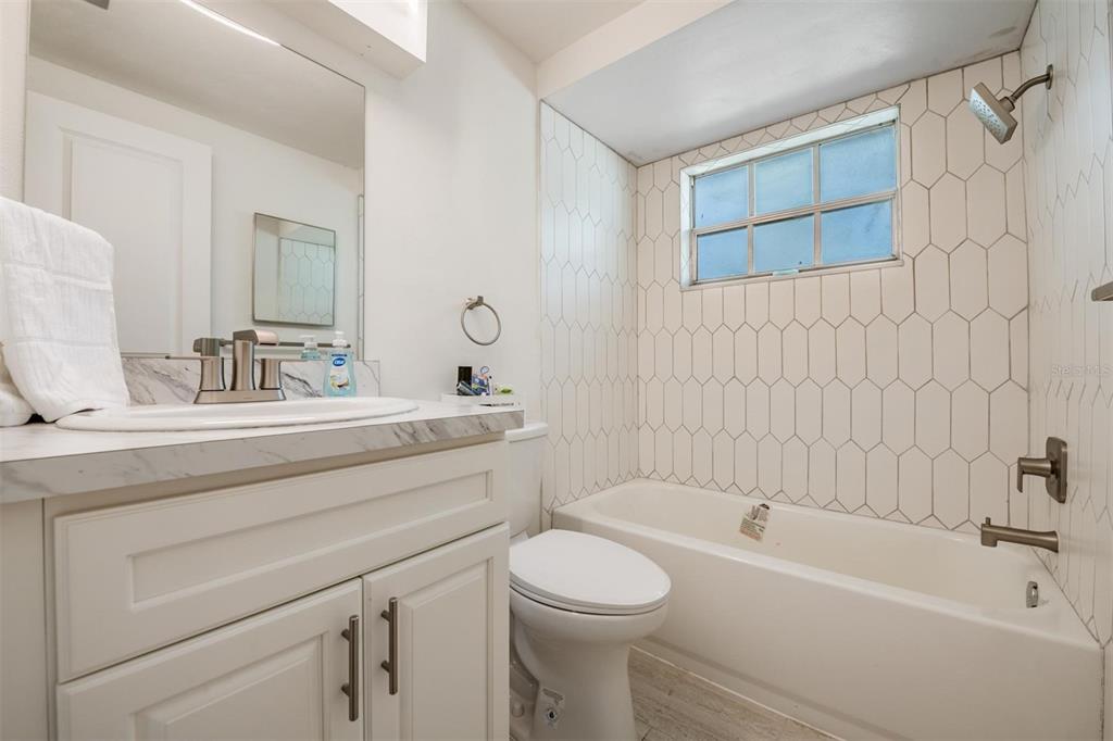 4450 Sunstate Drive New Port Richey, FL 34652 - Photo 17 of 29 a bathroom with a toilet a sink a mirror a bathtub and vanity