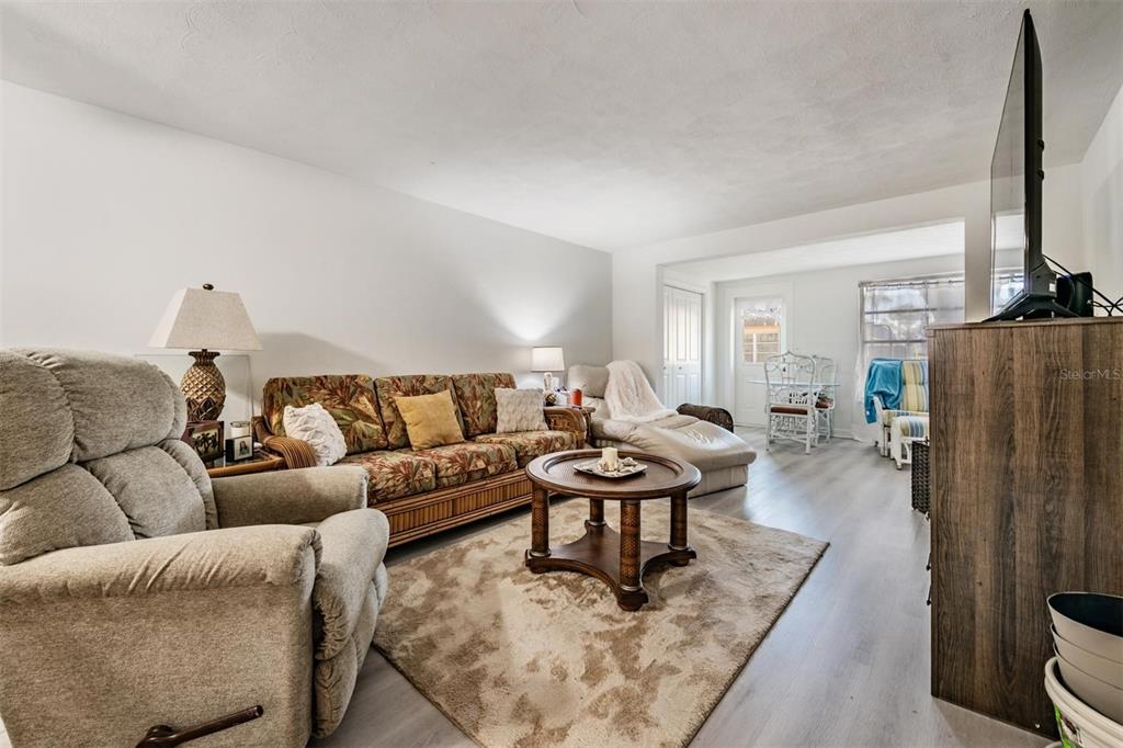 4450 Sunstate Drive New Port Richey, FL 34652 - Photo 2 of 29 a living room with furniture a large mirror and a table