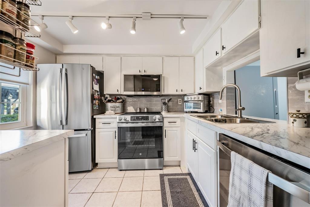 4450 Sunstate Drive New Port Richey, FL 34652 - Photo 9 of 29 a kitchen with stainless steel appliances granite countertop a stove a sink and a refrigerator