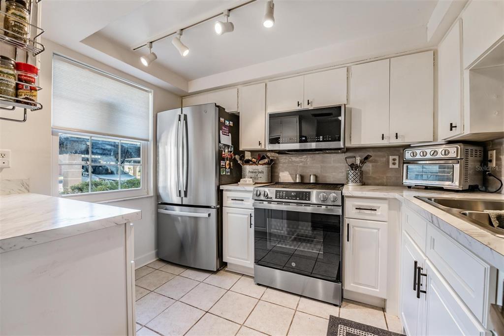 4450 Sunstate Drive New Port Richey, FL 34652 - Photo 10 of 29 a kitchen with cabinets stainless steel appliances and a counter space