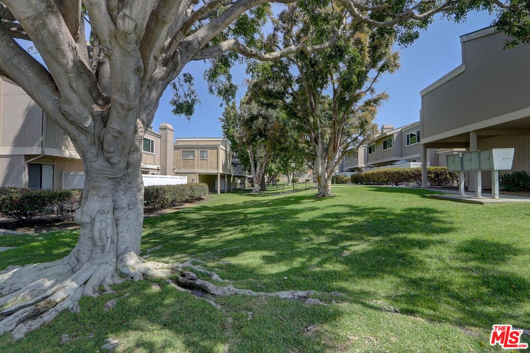 1275 Seacliff Court, Unit 5 Ventura, CA 93003 - Photo 18 of 25 a view of a yard in front of a brick house with a large tree