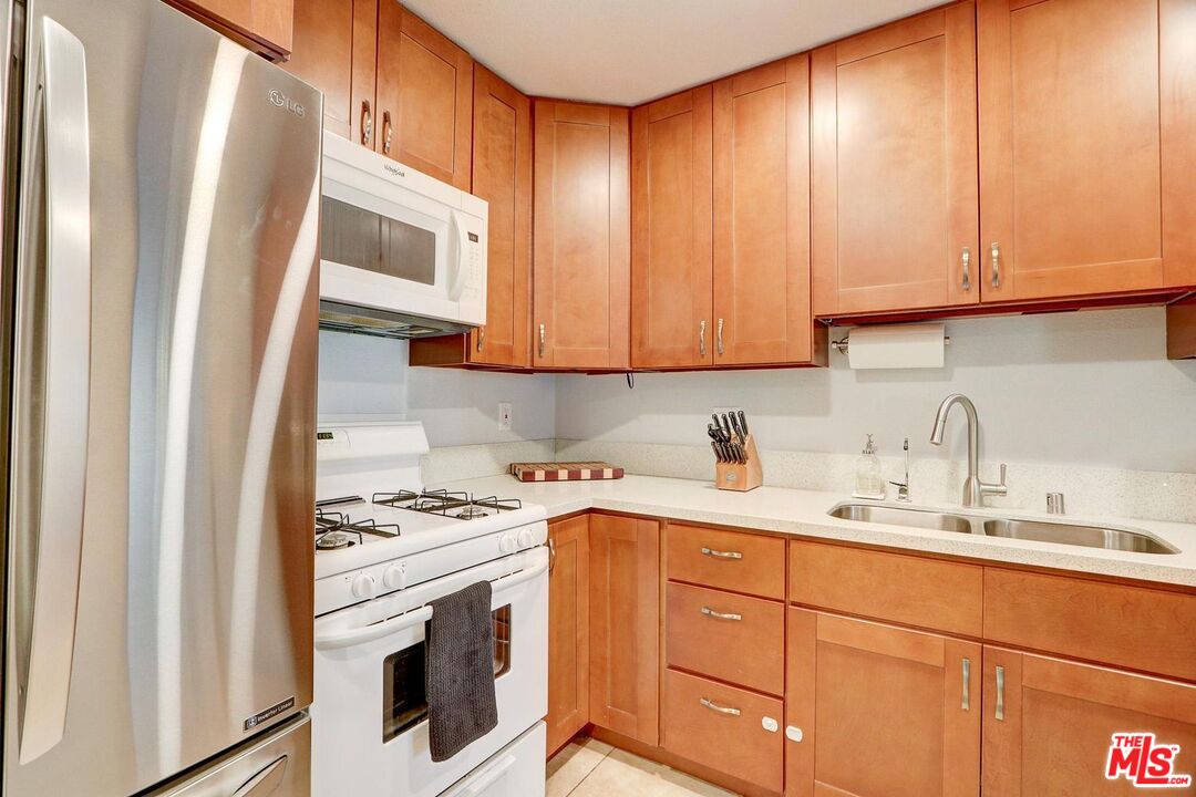 1275 Seacliff Court, Unit 5 Ventura, CA 93003 - Photo 4 of 25 a kitchen with granite countertop cabinets stainless steel appliances and sink