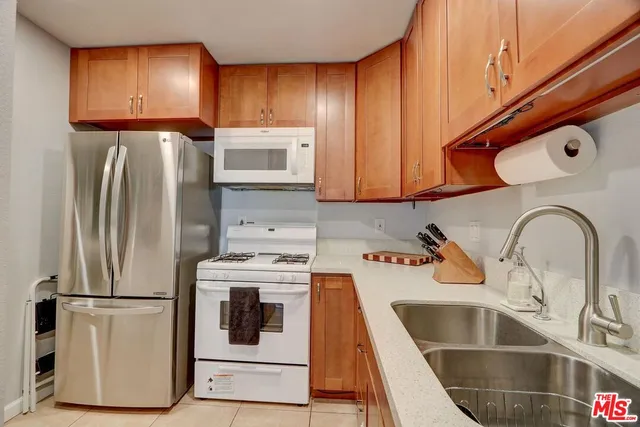 a kitchen with a refrigerator sink and cabinets
