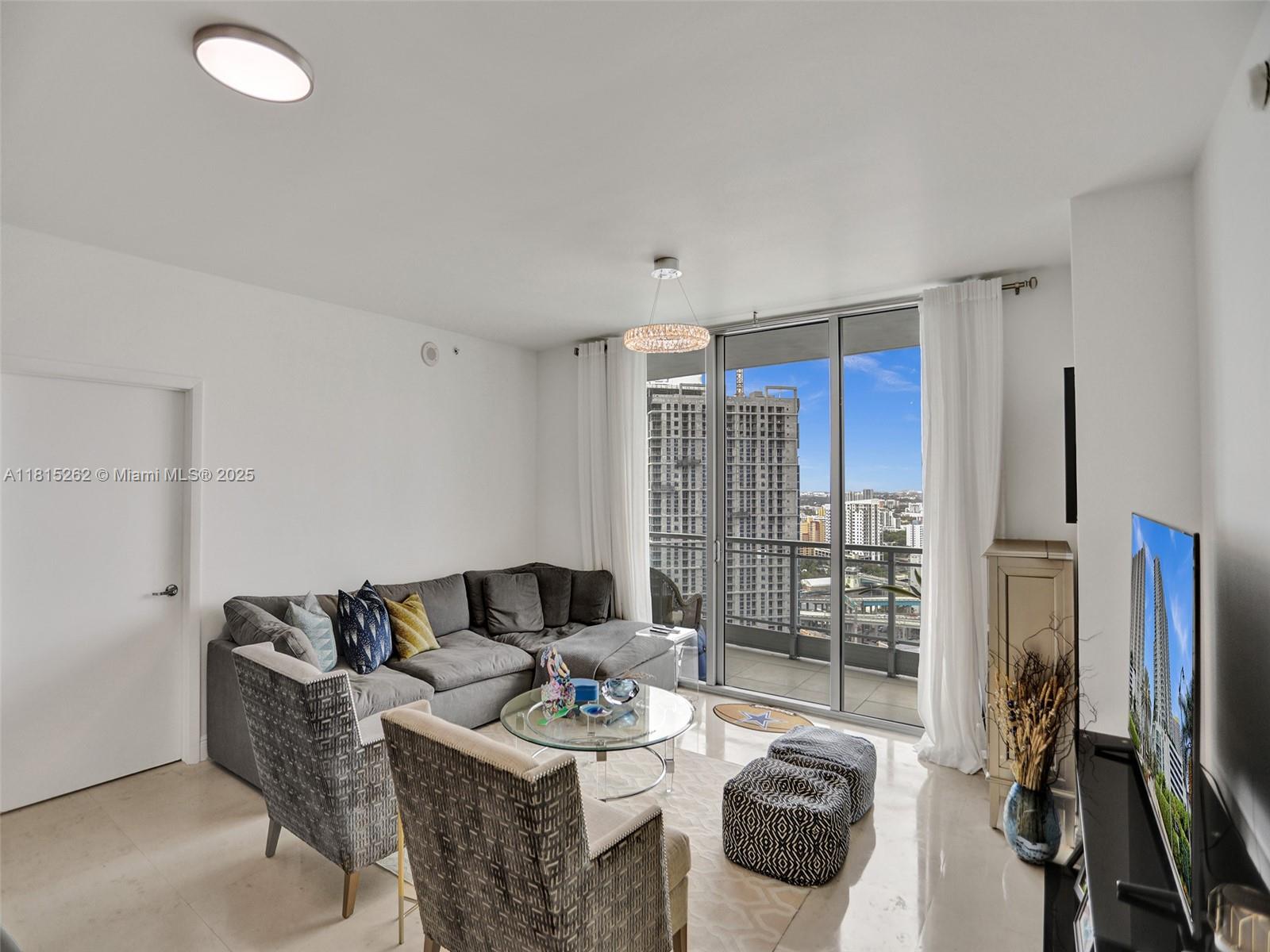 90 Southwest 3rd Street, Unit 2809 Miami, FL 33130 - Photo 15 of 67 a living room with furniture a floor to ceiling window and flat screen tv
